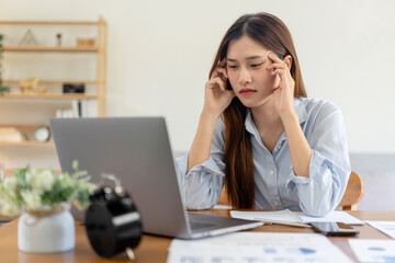 Female freelance is feeling stressful and headache from thinking the strategy plan of the business