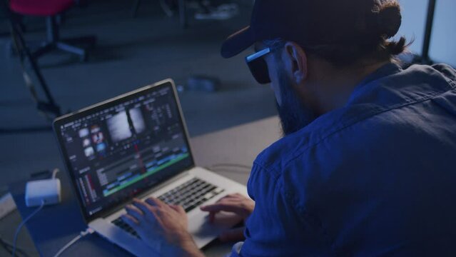 a male video editor is engaged in processing on a laptop in the studio