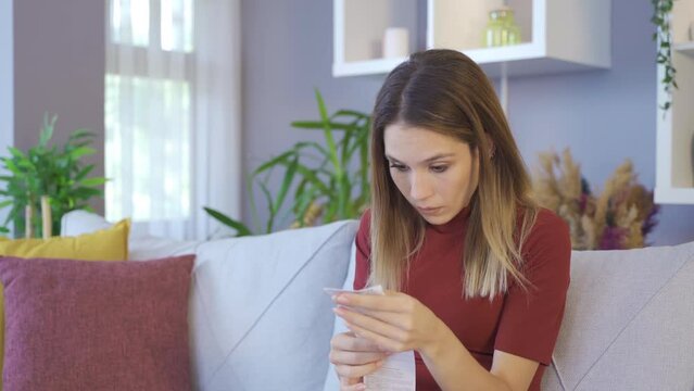 Surprised woman. Confused woman looking at high priced bill.
The fee written on the receipt or invoice in her hand surprises the woman and she thinks it is expensive.
