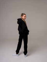 girl with long hair in a black tracksuit