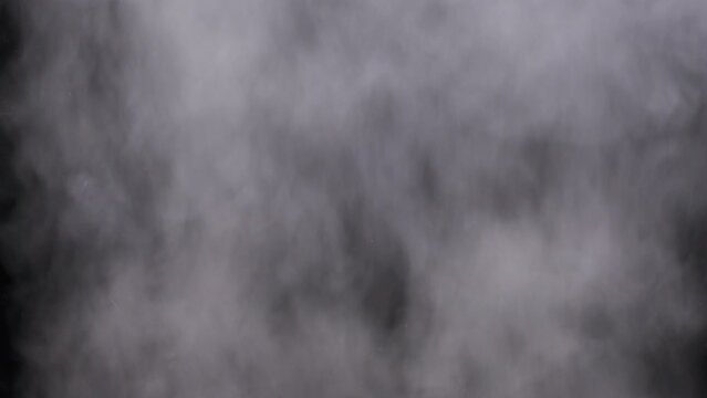 Realistic smoke or vapor clouds rise up, use in composite and video editing. Special effect, texture, footage. Smoke atmosphere fog overlay on black background. Abstract particles of steam texture. 4K