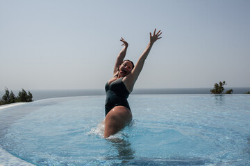 The overweight woman dressed swimming suit swimming the pool, have a vacation in a luxury hotel