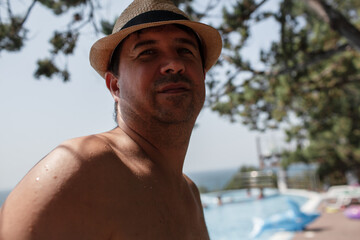 Portrait of a man posing against the swimming pool in the hotel