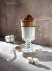 Dalgona coffee in the glass with cocoa and sugar on the table