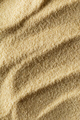 vertical sandy light background format 2:3 with waves of sand macro