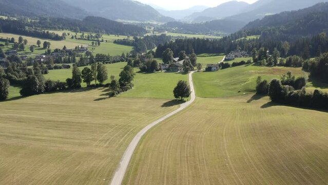 Landscape in the mountains. Slow descending drone shot of a way leading through meadows. Summertime at the Wilde Kaiser mountain in Austria.
