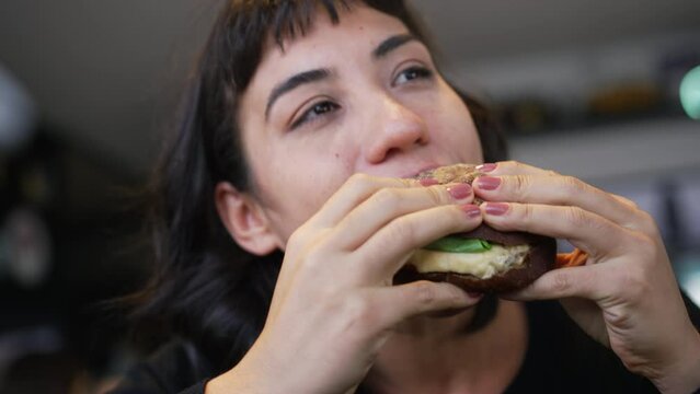 Person eating hamburger. Closeup girl holding delicious fast food burger