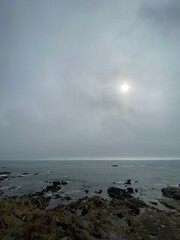Grey cloudy coastal landscape on the shore of a quiet rocky beach at autumn