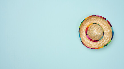 Straw mexican hat on blue background, top view