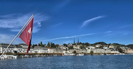 Blick auf Luzern am Vierwaldstätter See in der Schweiz mit der schweizer Fahne im Vordergrund