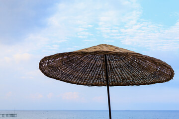 Wooden natural umbrella for relaxing in the shade of tourists on the beach. Background with copy space