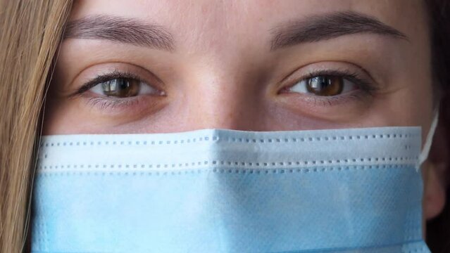 Portrait of beautiful young woman female doctor wearing medical face mask indoors. Medicine, people and infectious diseases concept.