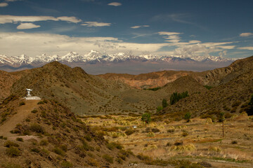Alpine landscape. View of the arid valley and Andes cordillera mountains in the horizon, under a beautiful blue sky in Pampa del Leoncito, San Juan, Argentina.