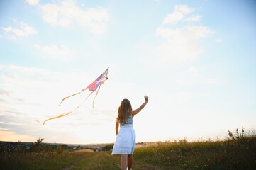 one happy little girl running on field with kite.