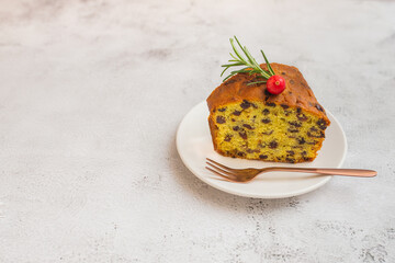 Slice of fresh baked raisin and fruit cake on a white plate. Traditional sweet fruit loaf.   