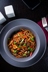 Soba beef and vegetables, Buckwheat noodles on a dark background. Traditional Asian food, Wok menu