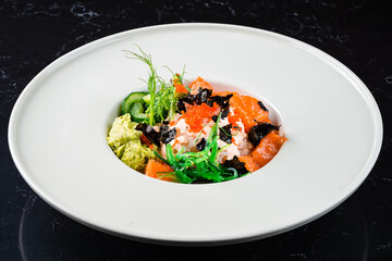 Delicate bowl of Norwegian salmon with wakame seaweed salad and diced ripe guacamole.