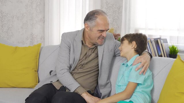 Grandparent relationship. The grandfather is chatting with his grandson.
Dede is chatting with his grandson and hugging him by kissing him.
