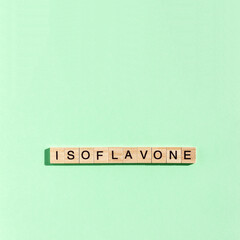 Word Isoflavone on wooden blocks with lettering on green background. Minimal menopause diet concept. Square orientation, copy space