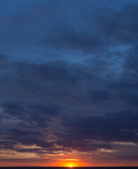 Landscape with bloody sunset. Panorama. Tragic gloomy sky. The last flashes of the sun on the storm clouds.