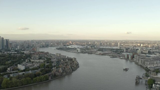 Following the river thames at sunset, city skyline and boats moving. O2 Greenwich Peninsula. 