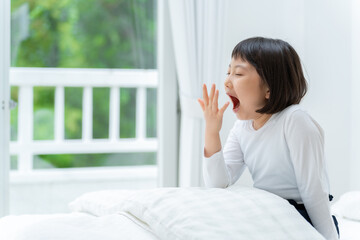 ベッドであくびをする女の子