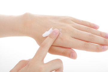 手にクリームを塗る女性。美容イメージ