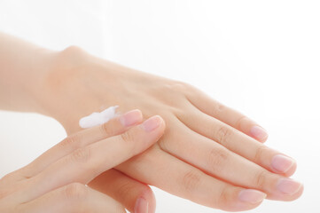 手にクリームを塗る女性。美容イメージ