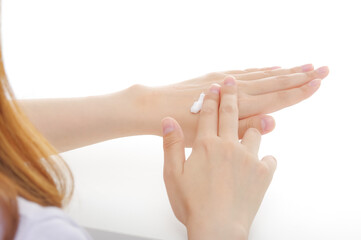 手にクリームを塗る女性。美容イメージ