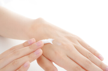 手にクリームを塗る女性。美容イメージ