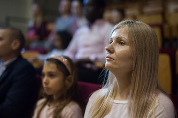 Obraz premium close up of european woman sitting at film in cinema auditorium .