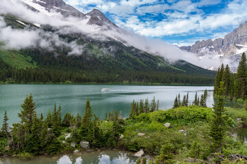 Lake Josephine in Glacier National Park as a boat passes by