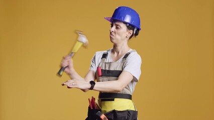 Strong contractor using mechanical hammer to fix nails, breaking and wrecking with sledgehammer. Working with manual mallet to hit wood and do construction rebuilding improvement.