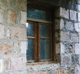 Old abandoned window in the wall of an old house