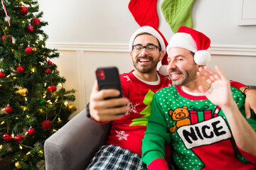 Happy gay couple on a video call with family on christmas