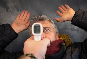 image fun et drôle d'un homme malade qui utilise un thermomètre comme une arme et qui vise son...