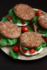 Healthy sandwiches with Philadelphia cheese, spinach and cherry tomatoes with rye buns.