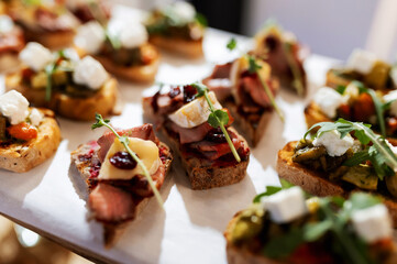 many small delicious sandwiches with bacon and cheese on the whole frame