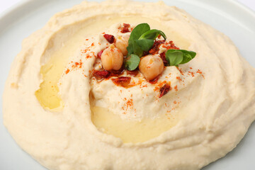 Plate of tasty hummus with garnish, closeup