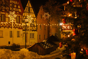 Christmas in Germany.half timbered houses and glowing decorations.Shining garlands of European Christmas streets.Dark background with shimmering golden garlands.