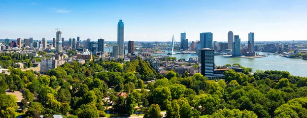 Fototapete Rotterdam Sommerliches Rotterdamer Stadtbild am Ufer der Nieuwe Maas mit Blick auf moderne Hochhäuser und stilvolle Erasmus-Schrägseilbrücke im Sommer, Luftaufnahme.