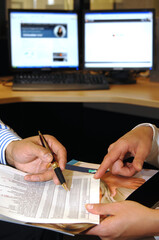 Business image-males hands working on a spread sheet hardcopy. - obrazy, fototapety, plakaty