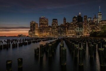 New York City skyline at twilight and sunset with skyscraper lights and piers and piles