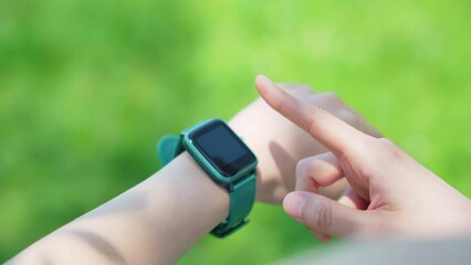 Woman using a smart watch outdoors. - Powered by Adobe