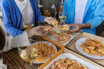 Celebrating with pizza on a tray and wine, a start-up party. new year party Company annual party alcoholic beverages company party ideas