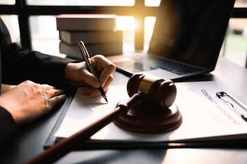 Close up of hand lawyer working signing contract paper with wooden gavel judge in the office,...