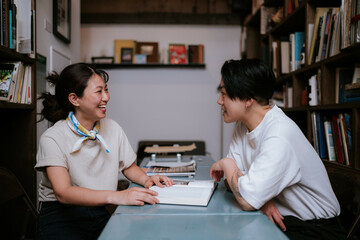 机に本を広げて読む二人の女性