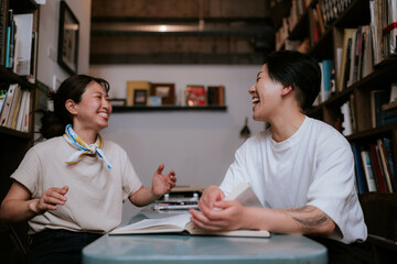机に本を広げて読む二人の女性
