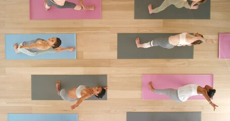 Class of women doing yoga or pilates exercise, stretching or workout for health, positive mindset and wellness above view. Relax group of people or fitness community training for body or inner peace