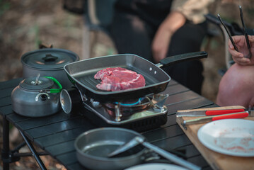 Young women enjoy to cooking meal on camping